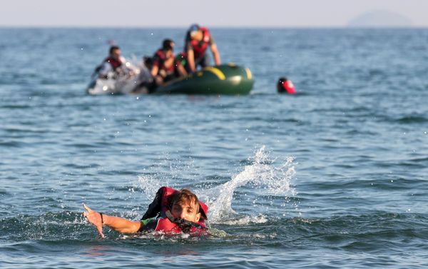 Migrants and refugees, one of them swims, arrive after crossing from Turkey, at the southeastern island of Kos, Greece, Monday, Aug. 17, 2015 - Sputnik International
