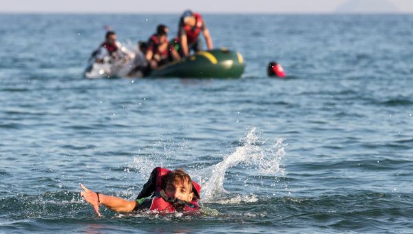 Migrants and refugees, one of them swims, arrive after crossing from Turkey, at the southeastern island of Kos, Greece, Monday, Aug. 17, 2015 - Sputnik International