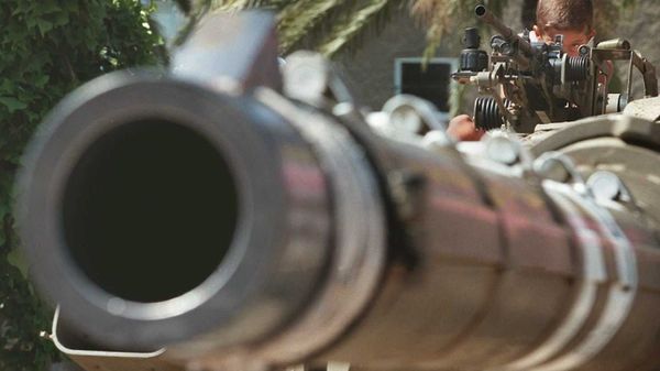 An Israeli child plays behind a heavy machine gun on a Merkava tank at the Rabin Square in Tel Aviv - Sputnik International