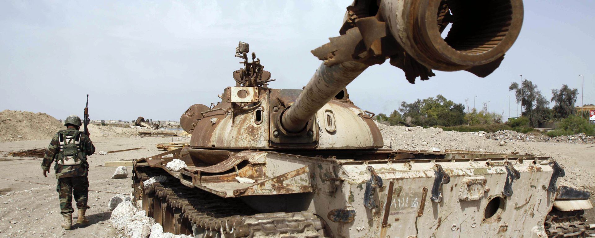 An Iraqi soldier is seen near an Iraqi Army tank, which was destroyed in the US-led invasion, in Basra, Iraq's second-largest city, 550 kilometers (340 miles) southeast of Baghdad, Iraq, Thursday, April 9, 2009 - Sputnik International, 1920, 18.03.2023