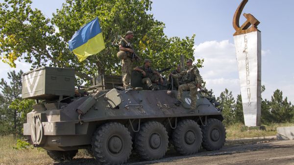 Ukrainian servicemen stand on an armoured personal carrier (APC) with an Ukrainian flag, before leaving for Ukrainian forces' positions in Staroignativka village, Donetsk region on August 12, 2015 - Sputnik International