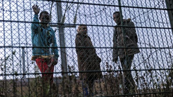 Migrants wait along the railway tracks of the Eurotunnel terminal at the Calais-Frethun station outside the northern French port of Calais on August 13, 2015 - Sputnik International