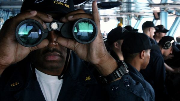 US Navy sailor CW02 Ernest Jackson, 42, of San Diego, California, peers through binoculars from the bridge of the USS Nimitz on Tuesday, June 5, 2007, in the Persian Gulf, where the Nimitz and the USS John C. Stennis aircraft carrier groups are on patrol - Sputnik International