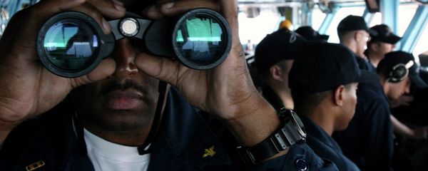 U.S. Navy sailor CW02 Ernest Jackson, 42, of San Diego, California, peers through binoculars from the bridge of the USS Nimitz on Tuesday, June 5, 2007, in the Persian Gulf, where the Nimitz and the USS John C. Stennis aircraft carrier groups are on patrol - Sputnik International