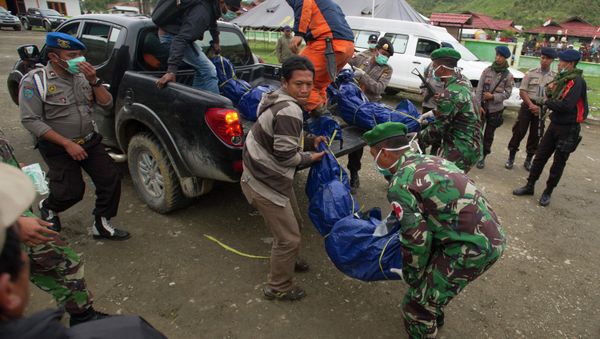 Members of the National Search and Rescue Agency carry the bodies of victims of the crashed Trigana Air Service flight upon arrival at Oksibil hospital in Pegunungan Bintang, Indonesia, Wednesday, Aug. 19, 2015 - Sputnik International