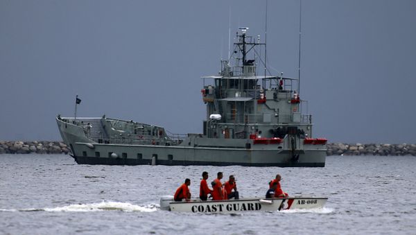 Members of the Philippine coast guard on a motorboat drive past one of the two decommissioned Landing Craft Heavy (LCH) vessels donated by the Australian government to the Philippines, docked at a bay in Manila August 9, 2015 Members of the Philippine coast guard on a motorboat drive past one of the two decommissioned Landing Craft Heavy (LCH) vessels donated by the Australian government to the Philippines, docked at a bay in Manila August 9, 2015 - Sputnik International