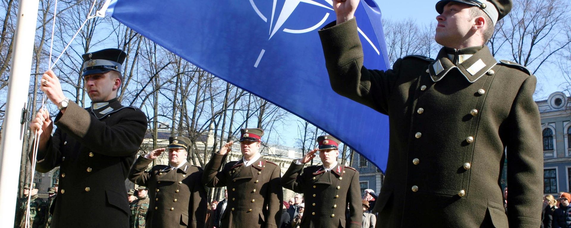 Latvian officers stand guard during the NATO flag rising ceremony in front of the Presidents castle in Riga Latvian officers stand guard during the NATO flag rising ceremony in front of the Presidents castle in Riga - Sputnik International, 1920, 10.01.2022