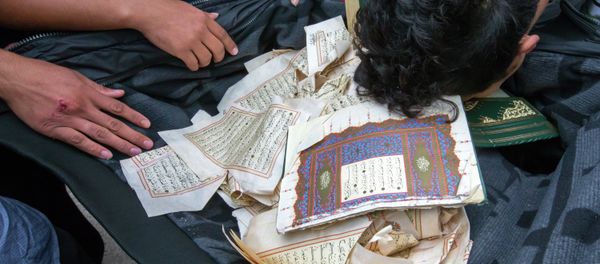 Refugees bow over ripped out pages from a Koran in a first registration center for refugees in Suhl, eastern Germany, on August 20, 2015 Refugees bow over ripped out pages from a Koran in a first registration center for refugees in Suhl, eastern Germany, on August 20, 2015 - Sputnik International