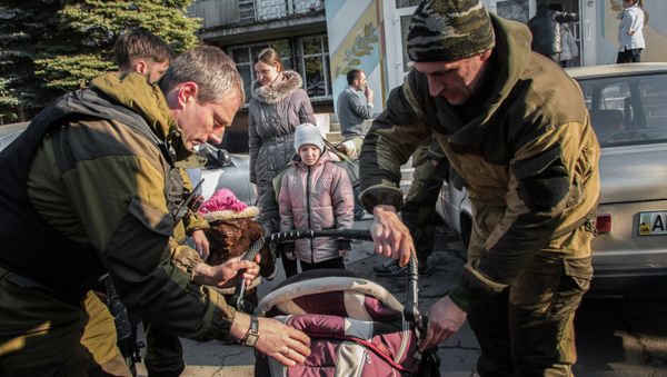 Militia of the Angel volunteer peacekeeping unit from the Donetsk and Luhansk People's Republics evacuate a woman and a child from the city of khartsyzsk Militia of the Angel volunteer peacekeeping unit from the Donetsk and Luhansk People's Republics evacuate a woman and a child from the city of khartsyzsk - Sputnik International