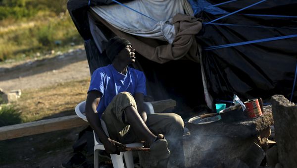 Khalifa, from Sudan breaks a branch to cooks at The New Jungle camp in Calais, France, August 9, 2015 - Sputnik International