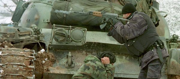 A Yugoslav special forces policeman shoots his rifle at opposing Kosovo Liberation Army forces as a Yugoslav Army tank driver covers his ears after coming under fire Tuesday Feb. 23, 1999 in the village of Bukos - Sputnik International