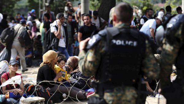 Macedonian special policemen guard the border as more than a thousand immigrants wait at the border line of Macedonia and Greece to enter Macedonia near the Gevgelija railway station August 21, 2015 - Sputnik International