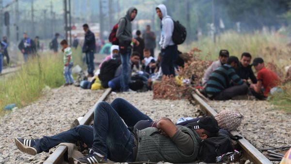 Migrants rest while waiting to pass the Greek-Macedonian border, guarded by Macedonian police near the town of Idomeni, northern Greece, on August 21, 2015 Migrants rest while waiting to pass the Greek-Macedonian border, guarded by Macedonian police near the town of Idomeni, northern Greece, on August 21, 2015 - Sputnik International