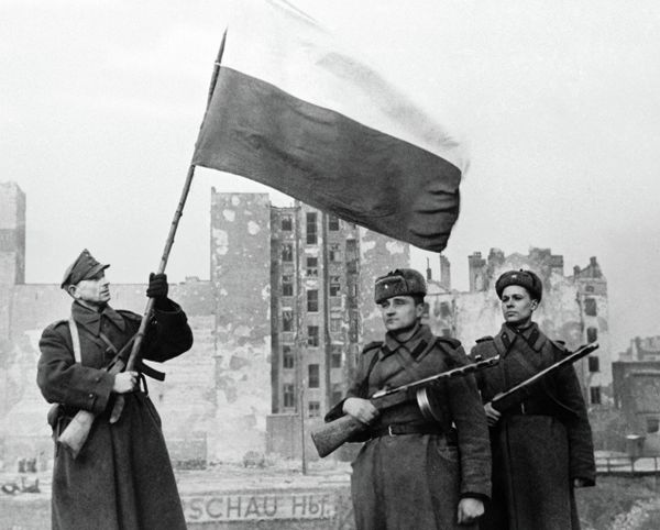 Soldiers of Wojsko Polske (left with flag) and Soviet Army (right) raising a flag in liberated Warsaw - Sputnik International