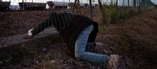 A migrant crawls under a fence as he attempts to access the Channel Tunnel in Calais, northern France, Saturday, Aug. 8, 2015 A migrant crawls under a fence as he attempts to access the Channel Tunnel in Calais, northern France, Saturday, Aug. 8, 2015 - Sputnik International