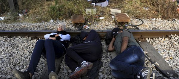 Migrants rest on a railway track at the Greek-Macedonian border, August 21, 2015 Migrants rest on a railway track at the Greek-Macedonian border, August 21, 2015 - Sputnik International