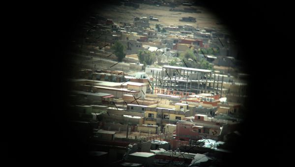 A picture taken through a machine gun sight on August 17, 2015 shows buildings that were damaged during fighting between Iraqi Kurdish Peshmerga fighters and the Islamic State (IS) group's militants in the northern Iraqi town of Sinjar, west of the city of Mosul. - Sputnik International