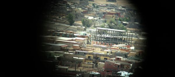 A picture taken through a machine gun sight on August 17, 2015 shows buildings that were damaged during fighting between Iraqi Kurdish Peshmerga fighters and the Islamic State (IS) group's militants in the northern Iraqi town of Sinjar, west of the city of Mosul. - Sputnik International