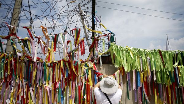 A tourist hangs a ribbon bearing messages wishing the unification of the two Koreas on a barbed-wire fence at the Imjingak pavilion near the demilitarized zone separating the two Koreas in Paju, South Korea A tourist hangs a ribbon bearing messages wishing the unification of the two Koreas on a barbed-wire fence at the Imjingak pavilion near the demilitarized zone separating the two Koreas in Paju, South Korea - Sputnik International