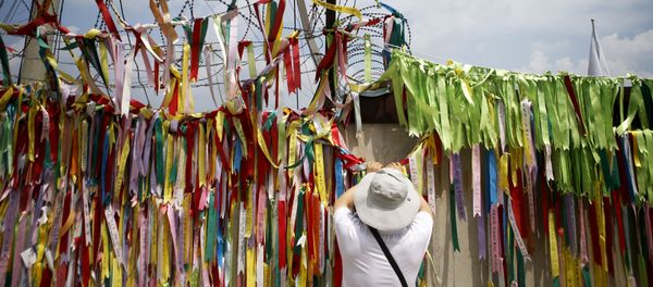 A tourist hangs a ribbon bearing messages wishing the unification of the two Koreas on a barbed-wire fence at the Imjingak pavilion near the demilitarized zone separating the two Koreas in Paju, South Korea - Sputnik International
