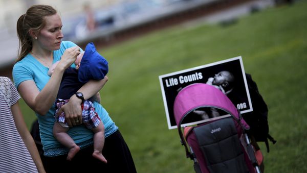 A woman holds her baby as she attends a Women Betrayed Rally to Defund Planned Parenthood at Capitol Hill in Washington. (File) - Sputnik International
