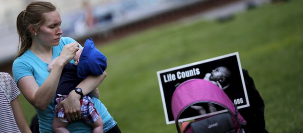 A woman holds her baby as she attends a Women Betrayed Rally to Defund Planned Parenthood at Capitol Hill in Washington. (File) - Sputnik International