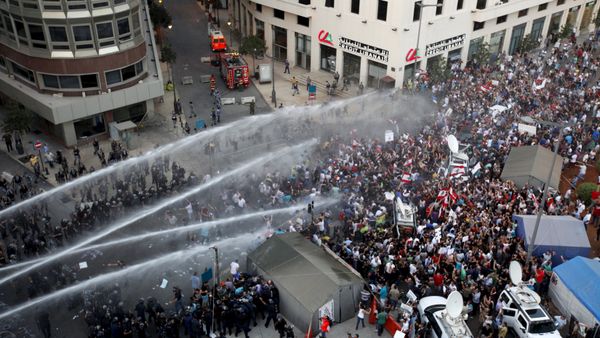 Lebanese protesters are sprayed with water during a protest against corruption and rubbish collection problems near the government palace in Beirut - Sputnik International