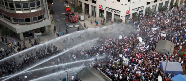 Lebanese protesters are sprayed with water during a protest against corruption and rubbish collection problems near the government palace in Beirut - Sputnik International