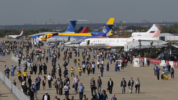 Visitors walk along a row of planes and helicopters on display at the MAKS International Aviation and Space Salon in Zhukovsky, outside Moscow, Russia, August 25, 2015 - Sputnik International