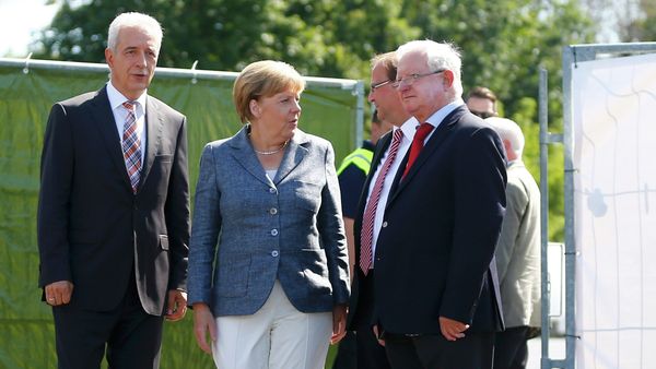 Saxony State Prime Minister Stanislaw Tillich, German Chancellor Angela Merkel, major Juergen Opitz and President of the German Red Cross Rudolf Seiters (LtoR) arrive to visit an asylum seekers accomodation facility in the eastern German town of Heidenau near Dresden, August 26, 2015 where last week more than 30 police were injured in clashes, when a mob of several hundred people pelted officers with bottles and fireworks Saxony State Prime Minister Stanislaw Tillich, German Chancellor Angela Merkel, major Juergen Opitz and President of the German Red Cross Rudolf Seiters (LtoR) arrive to visit an asylum seekers accomodation facility in the eastern German town of Heidenau near Dresden, August 26, 2015 where last week more than 30 police were injured in clashes, when a mob of several hundred people pelted officers with bottles and fireworks - Sputnik International