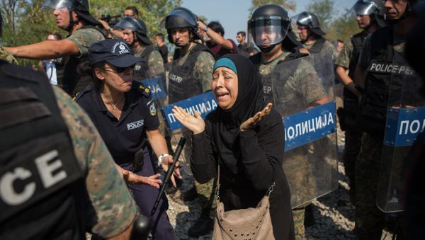 A Syrian refugee cries after she lost her daughter during clashes between Macedonian police and refugees who try to cross the borders in the town of Idomeni, Northern Greece, on Wednesday, Aug. 26, 2015. - Sputnik International