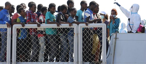 Migrants wait to disembark from an Italian navy vessel in the Sicilian harbour of Augusta, Italy, August 23, 2015 - Sputnik International