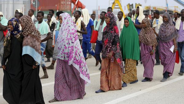 Migrants walk on the dock after disembarking from a Medecins Sans Frontieres ship carrying 320 migrants in the Sicilian harbour of Augusta, Italy, August 25, 2015 - Sputnik International