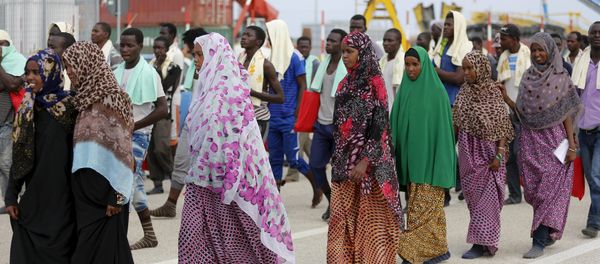 Migrants walk on the dock after disembarking from a Medecins Sans Frontieres ship carrying 320 migrants in the Sicilian harbour of Augusta, Italy, August 25, 2015 Migrants walk on the dock after disembarking from a Medecins Sans Frontieres ship carrying 320 migrants in the Sicilian harbour of Augusta, Italy, August 25, 2015 - Sputnik International