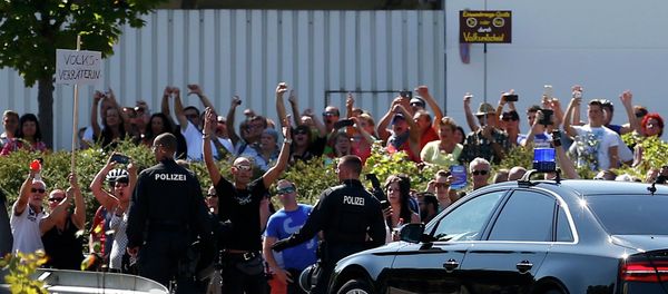 People hold a placard reading Traitor as German Chancellor Angela Merkel leaves after her visit to an asylum seekers accomodation facility in the eastern German town of Heidenau near Dresden, August 26, 2015 where last week more than 30 police were injured in clashes, when a mob of several hundred people pelted officers with bottles and fireworks People hold a placard reading Traitor as German Chancellor Angela Merkel leaves after her visit to an asylum seekers accomodation facility in the eastern German town of Heidenau near Dresden, August 26, 2015 where last week more than 30 police were injured in clashes, when a mob of several hundred people pelted officers with bottles and fireworks - Sputnik International