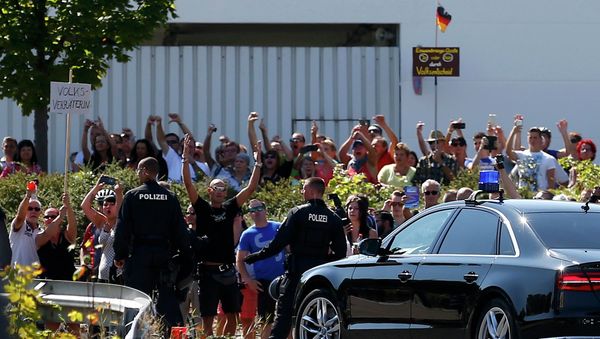 People hold a placard reading Traitor as German Chancellor Angela Merkel leaves after her visit to an asylum seekers accomodation facility in the eastern German town of Heidenau near Dresden, August 26, 2015 where last week more than 30 police were injured in clashes, when a mob of several hundred people pelted officers with bottles and fireworks People hold a placard reading Traitor as German Chancellor Angela Merkel leaves after her visit to an asylum seekers accomodation facility in the eastern German town of Heidenau near Dresden, August 26, 2015 where last week more than 30 police were injured in clashes, when a mob of several hundred people pelted officers with bottles and fireworks - Sputnik International