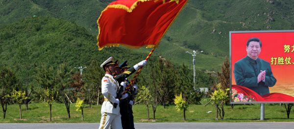 Chinese flag bearers practice marching near a portrait of Chinese President Xi Jinping ahead of a Sept. 3 military parade. - Sputnik International