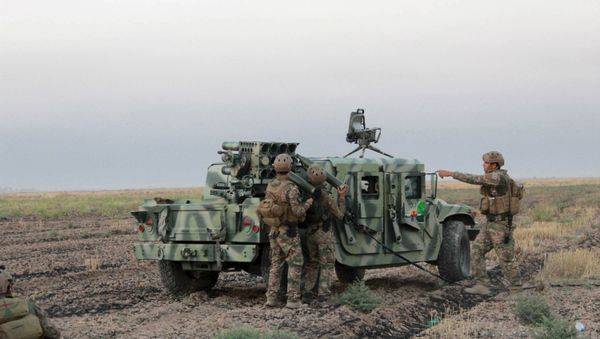 Kurdish Peshmerga fighters reload a weapon during clashes with Islamic State militants south of Daquq, north of Baghdad August 26, 2015 - Sputnik International