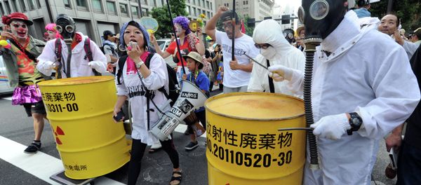 Protesters wearing gas masks and white costumes similar to those of decontamination workers at the crippled Fukushima plant beat drums painted with radioactive waste symbols during an anti nuclear power demonstration march in Tokyo on July 29, 2012 Protesters wearing gas masks and white costumes similar to those of decontamination workers at the crippled Fukushima plant beat drums painted with radioactive waste symbols during an anti nuclear power demonstration march in Tokyo on July 29, 2012 - Sputnik International