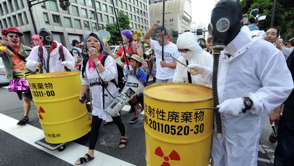 Protesters wearing gas masks and white costumes similar to those of decontamination workers at the crippled Fukushima plant beat drums painted with radioactive waste symbols during an anti nuclear power demonstration march in Tokyo on July 29, 2012 Protesters wearing gas masks and white costumes similar to those of decontamination workers at the crippled Fukushima plant beat drums painted with radioactive waste symbols during an anti nuclear power demonstration march in Tokyo on July 29, 2012 - Sputnik International