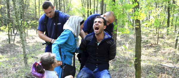 Hungarian policemen detain a Syrian migrant family after they entered Hungary at the border with Serbia, near Roszke, August 28, 2015. Hungarian policemen detain a Syrian migrant family after they entered Hungary at the border with Serbia, near Roszke, August 28, 2015. - Sputnik International