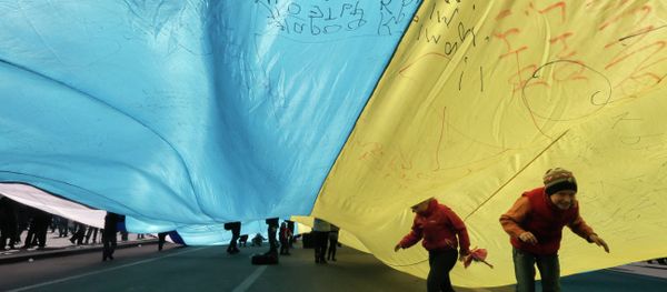 Ukrainian kids play under a huge yellow-and-blue Ukrainian national flag at a rally in Kiev's Independent square, Ukraine, Saturday, April 5, 2014 Ukrainian kids play under a huge yellow-and-blue Ukrainian national flag at a rally in Kiev's Independent square, Ukraine, Saturday, April 5, 2014 - Sputnik International