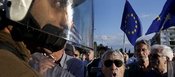 Riot police stand between anti-austerity and pro-EU protesters in front of the parliament building during a rally calling on the government to clinch a deal with its international creditors and secure Greece's future in the eurozone in Athens, Greece, in this June 22, 2015 file photo Riot police stand between anti-austerity and pro-EU protesters in front of the parliament building during a rally calling on the government to clinch a deal with its international creditors and secure Greece's future in the eurozone in Athens, Greece, in this June 22, 2015 file photo - Sputnik International
