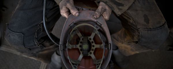 A Ukrainian coal miner holds his helmet after finishing his shift at a coal mine outside Donetsk, Ukraine - Sputnik International