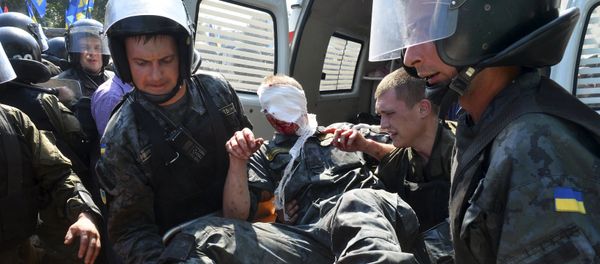 Ukrainian national guard officers carry an injured comrade on a stretcher outside the parliament building in Kiev, Ukraine, August 31, 2015 - Sputnik International