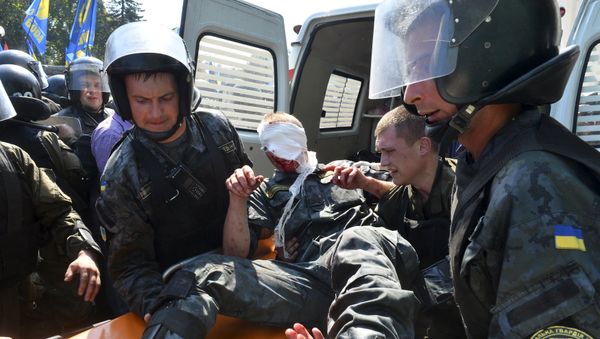 Ukrainian national guard officers carry an injured comrade on a stretcher outside the parliament building in Kiev, Ukraine, August 31, 2015 Ukrainian national guard officers carry an injured comrade on a stretcher outside the parliament building in Kiev, Ukraine, August 31, 2015 - Sputnik International