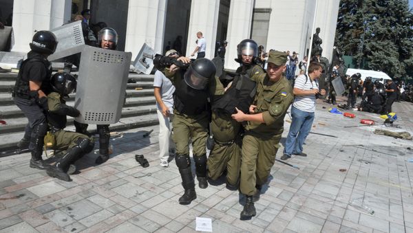 Ukrainian national guard officers carry an injured colleague to an ambulance outside the parliament building in Kiev, Ukraine, August 31, 2015 - Sputnik International