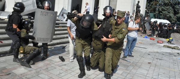 Ukrainian national guard officers carry an injured colleague to an ambulance outside the parliament building in Kiev, Ukraine, August 31, 2015 Ukrainian national guard officers carry an injured colleague to an ambulance outside the parliament building in Kiev, Ukraine, August 31, 2015 - Sputnik International