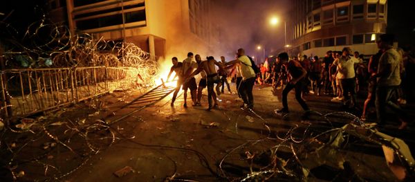 Lebanese protesters set fire to barriers and trash behind the barbed wire Lebanese protesters set fire to barriers and trash behind the barbed wire - Sputnik International