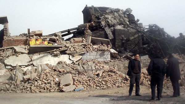 Police and officials stand beside debris from a collapsed mine. - Sputnik International